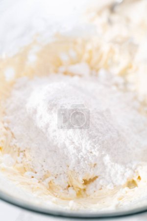 Foto de Mezclar los ingredientes en un tazón grande para preparar glaseado de queso crema. - Imagen libre de derechos