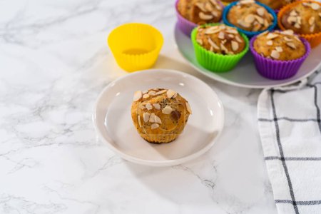 Téléchargez les photos : Muffins de graines de pavot citron fraîchement cuits garnis de lamelles d'amande sur le comptoir de la cuisine. - en image libre de droit