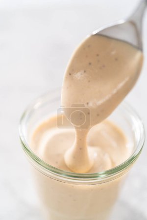 Photo for Homemade Swedish meatball sauce in a glass jar on a kitchen counter. - Royalty Free Image