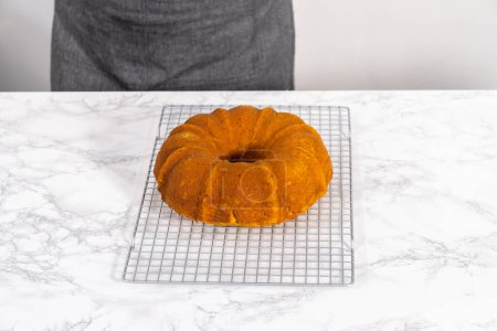 Photo for Cooling freshly baked pumpkin bunt cake on a kitchen counter. - Royalty Free Image