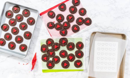 Foto de Acostado. Decoración de galletas de chocolate con corazones de chocolate rojo. - Imagen libre de derechos