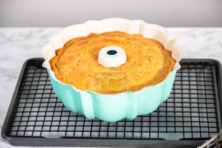 Photo for Cooling freshly baked a lemon pound cake on a cooling kitchen rack. - Royalty Free Image