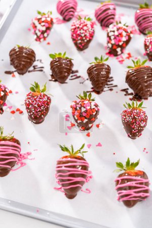 Foto de Decoración de fresas cubiertas de chocolate con lloviznas y chispas de chocolate. - Imagen libre de derechos