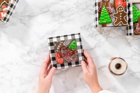 Téléchargez les photos : Pose plate. Emballage d'une variété maison de biscuits au caramel et au pain d'épice pour les cadeaux alimentaires de Noël dans des boîtes en papier. - en image libre de droit