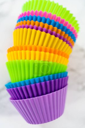 Téléchargez les photos : Nouvelles doublures de cupcake en silicone de différentes couleurs sur le comptoir de la cuisine. - en image libre de droit