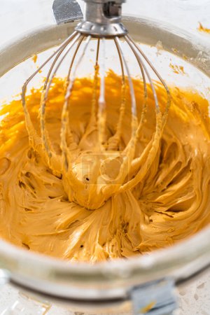 Téléchargez les photos : Fouetter les ingrédients dans un mélangeur électrique stand pour faire glaçage dulce de leche buttercream. - en image libre de droit