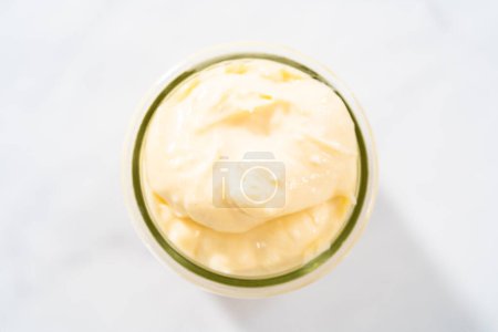 Foto de Relleno de queso crema para pastel de paquete en jat de vidrio pequeño. - Imagen libre de derechos