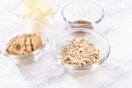 Photo for Measured ingredients in a glass mixing bowl to prepare cinnamon crumb topping. - Royalty Free Image