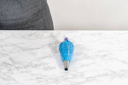 Téléchargez les photos : Buttercream glaçage dans des sacs de tuyauterie avec des pointes métalliques sacs de tuyauterie pour décorer drapeau américain mini cupcakes. - en image libre de droit