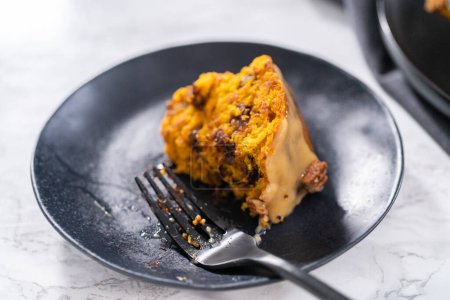 Téléchargez les photos : Tranche de gâteau bundt à la citrouille au chocolat maison avec glaçage au caramel sur une assiette. - en image libre de droit