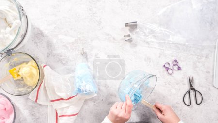 Photo for Flat lay. Step by step. Transfering meringue mix into piping bags with metal tips to bake unicorn meringue pops cookies. - Royalty Free Image
