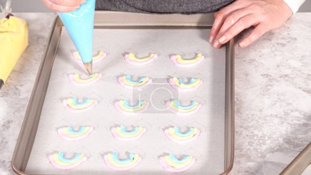 Photo for Step by step. Piping meringue mix into unicorn-shaped pops on a baking sheet lined with parchment paper. - Royalty Free Image