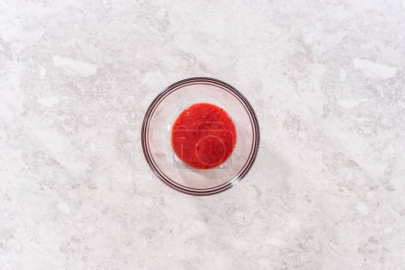 Téléchargez les photos : Pose plate. Mélange de fraises fraîches dans un mélangeur de cuisine pour préparer le glaçage à la crème au beurre aux fraises. - en image libre de droit