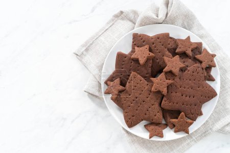 Photo for Freshly baked star-shaped chocolate graham crackers on a white plate. - Royalty Free Image