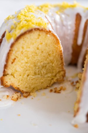 Foto de Tarta de limonada en rodajas decorada con ralladura de limón en un soporte de pastel. - Imagen libre de derechos