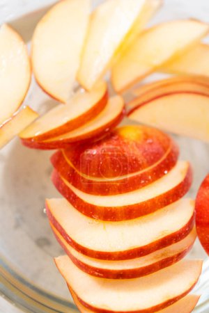 Téléchargez les photos : Laver les tranches de pomme dans le mélange d'eau pour les empêcher de brunir. - en image libre de droit