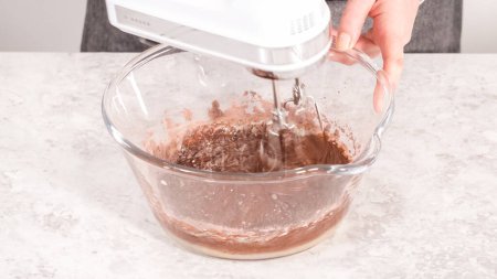 Foto de Paso a paso. Mezclar ingredientes para hornear cupcakes de chocolate arcoíris unicornio. - Imagen libre de derechos