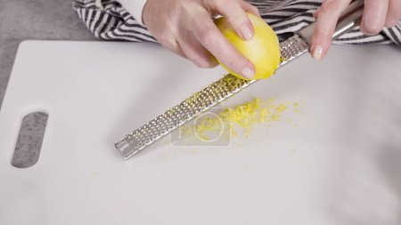 Photo for Zesting organic lemons to bake a lemon pound cake. - Royalty Free Image