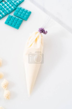 Foto de Rocía chocolate blanco derretido y espolvorea con azúcar blanco perla espolvorea sobre el mini bardo de chocolate. - Imagen libre de derechos