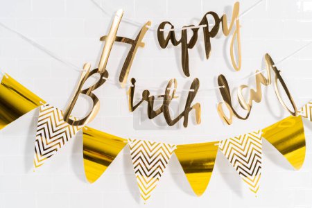 Téléchargez les photos : Papier Happy Birthday bannière en papier doré dans la cuisine. - en image libre de droit