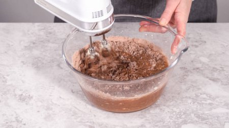 Foto de Paso a paso. Mezclar los ingredientes en un tazón de vidrio para preparar pastel de terciopelo rojo. - Imagen libre de derechos