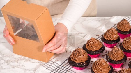 Foto de Paso a paso. Envasar cupcakes de chocolate con glaseado de ganache de chocolate en una caja de cupcakes de papel. - Imagen libre de derechos