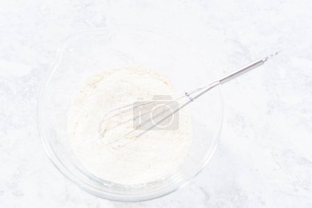 Téléchargez les photos : Mélanger les ingrédients dans un bol de mélange en verre pour cuire le gâteau bundt funfettti. - en image libre de droit