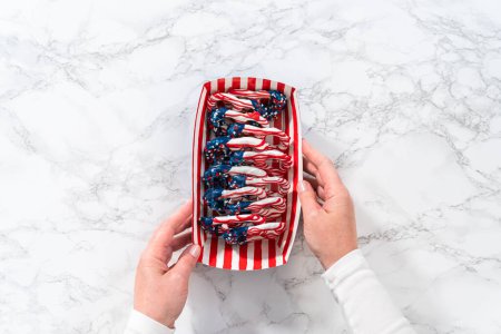Foto de Flat lay. American flag. Red, white, and blue chocolate-covered pretzel twists. - Imagen libre de derechos