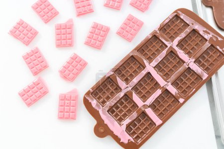 Foto de Extracción de mini chocolates rosados del molde de chocolate de silicona. - Imagen libre de derechos