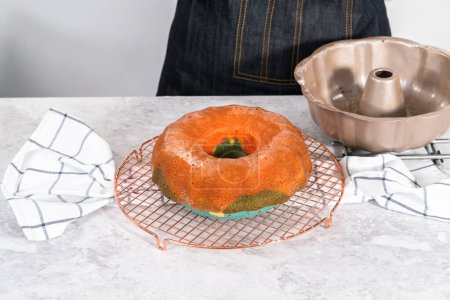 Photo for Cooling freshly baked bundt cake on a round cooling rack. - Royalty Free Image