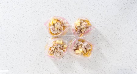 Photo for Flat lay. Packaging homemade frozen shrimp scampi meal prep into plastic resealable bags. - Royalty Free Image