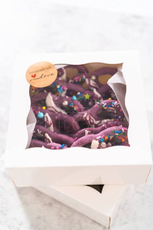 Photo for Packaging homemade mermaid pretzel twists into a white paper box. - Royalty Free Image