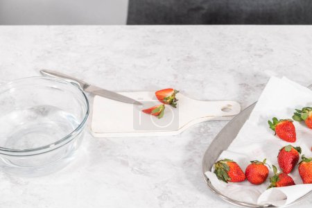 Photo for Slicing fresh organic strawberries on a white cutting board. - Royalty Free Image