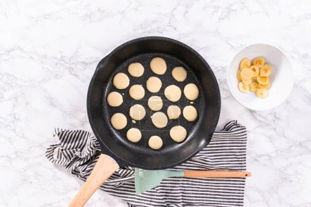 Flat lay. Frying mini pancake cereal in a nonstick frying pan.