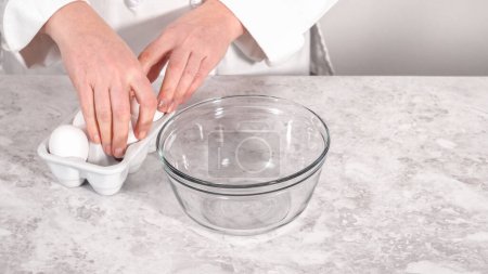 Foto de Paso a paso. Mezclar los ingredientes en un tazón de vidrio para hornear pastel de paquete funfettti. - Imagen libre de derechos