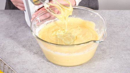 Foto de Paso a paso. Mezclar los ingredientes en un tazón de vidrio para preparar pastel de limonero. - Imagen libre de derechos