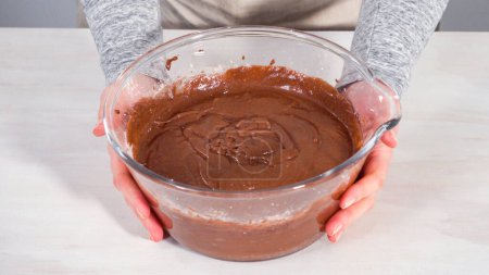 Photo for Step by step. Mixing ingredients in a glass mixing bowl to bake chocolate bundt cake with chocolate frosting. - Royalty Free Image