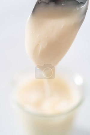 Photo for Cream cheese glaze in small glass jat. - Royalty Free Image
