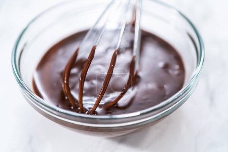 Téléchargez les photos : Préparation de ganache au chocolat dans un bol à mélanger en verre. - en image libre de droit