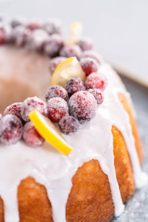 Foto de Tarta de limonada de arándanos rojos decorada con arándanos azucarados y cuñas de limón en un puesto de pastel. - Imagen libre de derechos