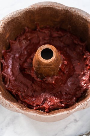 Foto de Llenado de pan de pastel de metal con mantequilla de pastel para hornear pastel de terciopelo rojo con glaseado de queso crema - Imagen libre de derechos