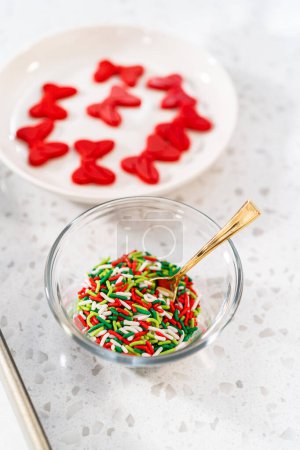 Téléchargez les photos : Ingrédients mesurés dans des bols à mélanger en verre pour faire une couronne de Noël bretzel au chocolat. - en image libre de droit