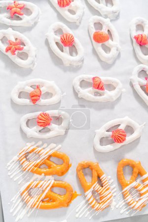 Photo for Gourmet chocolate-covered pretzel twists with seashell-shaped chocolates. - Royalty Free Image