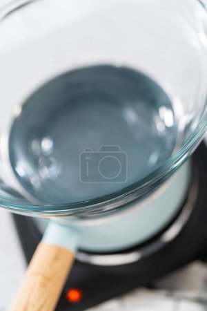Foto de Ingredientes medidos en cuencos mezcladores de vidrio para hacer caramelo de menta cortador de galletas de Navidad. - Imagen libre de derechos