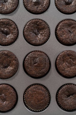 Téléchargez les photos : Refroidissement des cupcakes au chocolat fraîchement cuits sur le comptoir. - en image libre de droit