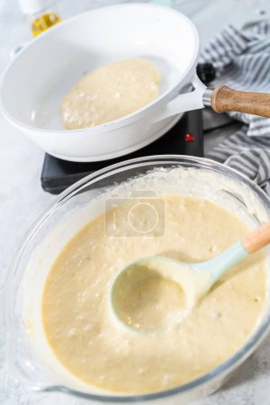 Téléchargez les photos : Pâte à crêpes dans un bol à mélanger en verre pour faire des crêpes à la banane à la noix de coco. - en image libre de droit