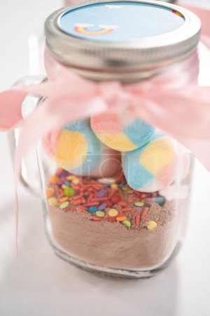 Photo for Making unicorn hot chocolate mix in drinking mason jar as a food gift. - Royalty Free Image