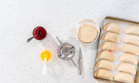 Photo for Flat lay. Filling empanada dough with cherry pie filling to make sweet cherry empanadas in the air fryer. - Royalty Free Image