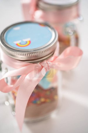 Photo for Making unicorn hot chocolate mix in drinking mason jar as a food gift. - Royalty Free Image