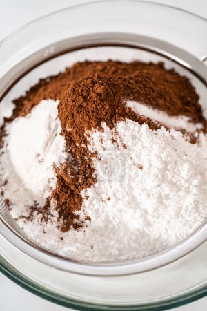 Photo for Sifting ingredients through hand sifter to make homemade hot chocolate mix. - Royalty Free Image